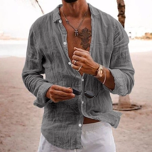 Detail of grey men's linen shirt showing breathable fabric texture against beach backdrop