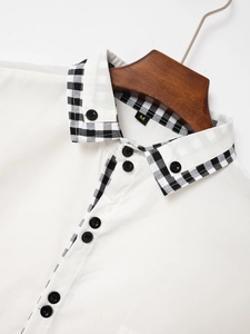 Detail of white cotton shirt featuring a stylish plaid inner collar and black buttons