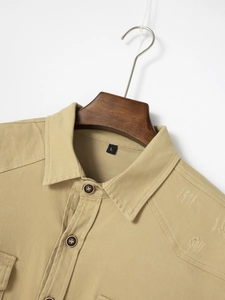 Detail of khaki twill cotton shirt collar with visible L size tag and button closure