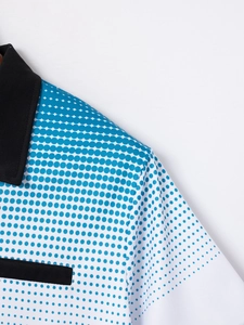 Detailed view of white Polo shirt featuring gradient blue polka dots and breathable fabric