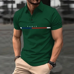 Detalle de polo verde oscuro con rayas tricolores y texto de París bordado en el pecho