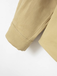 Macro detail of stitching on khaki cotton long sleeve shirt cuffs and bottom hem