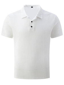 Détail de polo blanc à maille gaufrée montrant le tissu texturé et boutons noirs