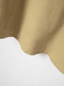 Macro shot of khaki cotton shirt hem showing double stitching and knit texture details