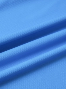 Détail du tissu en maille bleue respirante avec micro-perforations pour polos de sport