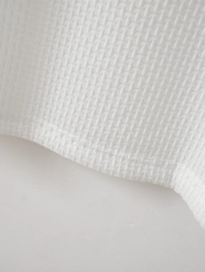 Vue macro de la texture du tissu gaufré blanc et détails des coutures plates de qualité