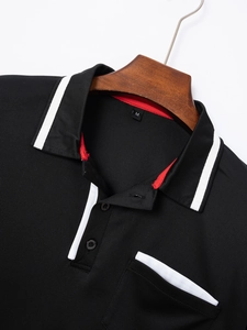 Detail eines schwarzen Poloshirts mit weißem Kontraststreifen an Kragen und Tasche