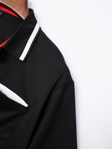 Detail eines schwarzen Poloshirts mit atmungsaktivem Mesh-Gewebe und weißen Kontraststreifen