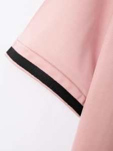 Detailansicht aus rosa Mesh-Gewebe mit schwarz gestreiften Ärmelbündchen am Polo