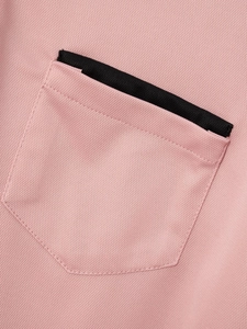 Nahaufnahme der Brusttasche am rosa Poloshirt mit schwarzem Kontraststreifen und Piqué-Stoff