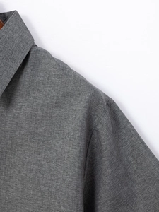 Dettaglio del colletto e della trama in lino grigio mélange di una camicia da uomo