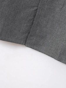Dettaglio della trama del tessuto grigio scuro e cuciture fini su camicia da uomo