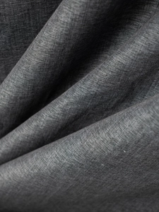 Macro detail of charcoal grey linen cotton fabric showing rich texture and soft drape