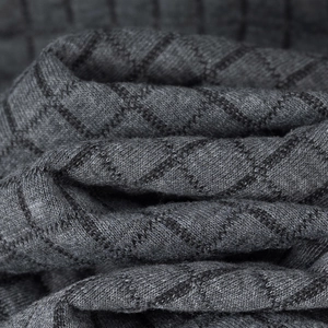 Macro shot of dark grey knit fabric with textured diamond pattern for men's polo shirts
