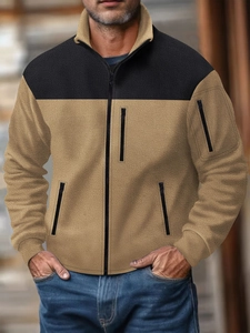 Detalle de chaqueta de forro polar camel y negro con bolsillos con cremallera y textura