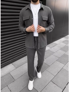 Outdoor shot of men's dark gray corduroy button shirt and drawstring pants set