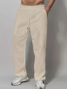 Men's off-white straight-leg cotton trousers with drawstring waist and textured fabric