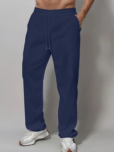 Close-up of men's navy blue cotton drawstring pants with side pockets and straight cut