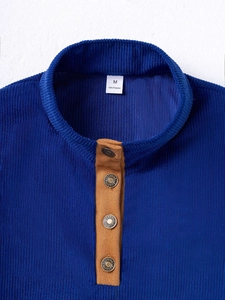 Detalle de sudadera de pana azul marino con cuello de antelina y botones metálicos