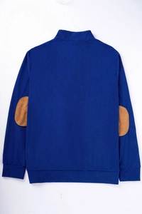 Detalle del jersey de pana azul marino con parches en los codos y dobladillo acanalado