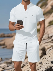 Men's white linen-like beach set with henley shirt and drawstring shorts on coast
