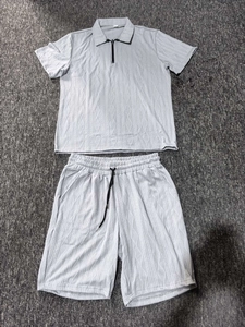 Detail of grey men's polo set showing 3D diamond texture and knit fabric quality