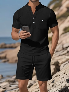 Men's casual black Henley T-shirt and shorts beach set on a bright seaside outdoor background