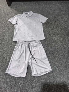Detail of grey men's polo set showing knitted vertical stripe texture and drawstring waist