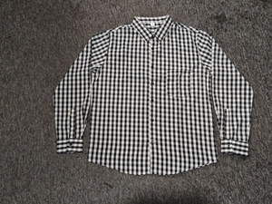 Close-up of the black and white plaid pattern and chest pocket on a casual shirt