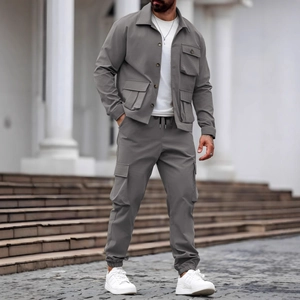 Detail view of heavy-duty mens grey utility jacket and cargo pants in outdoor setting