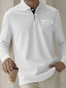 Detail of white long-sleeve polo shirt showing waffle texture and buttoned chest pocket