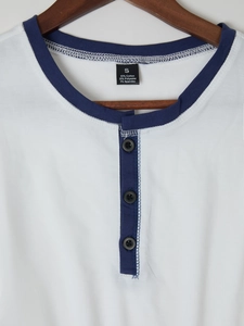 Detail view of cotton blend fabric and three-button contrast henley neckline on a shirt