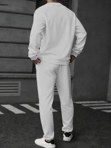 Détail du tissu texturé et des poignets côtelés sur l'ensemble beige pour homme de dos