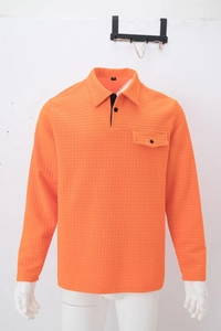 Detail of orange waffle knit polo shirt showing chest pocket and buttoned collar