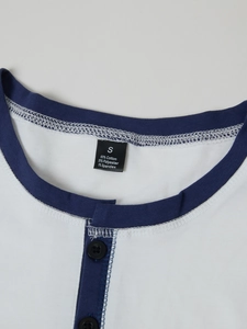 Detail of Henley shirt neckline featuring blue contrast binding and black buttons