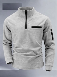 Detail of light grey waffle texture polo shirt with standing collar and arm zipper pocket