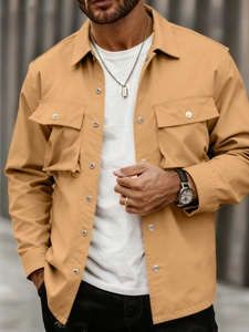 Detailed close-up of khaki utility jacket showing collar, flap pockets and metal buttons