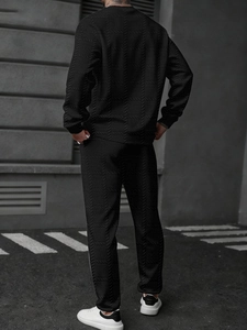 Détail du survêtement noir pour homme montrant la texture jacquard et la bande latérale blanche
