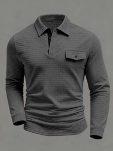 Detail of dark grey waffle texture polo shirt featuring buttoned chest pocket and collar