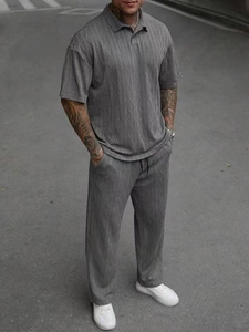 Detailed close-up of dark grey men's knit polo set with textured cable knit fabric