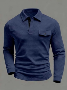 Detail of navy blue long sleeve polo shirt with waffle texture and button chest pocket
