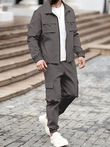 Detail van heren donkergrijze cargo jack en broek set met grote functionele zakken