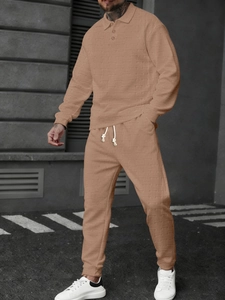 Detail of men's polo set showing textured fabric with ribbed long sleeves and drawstring pants