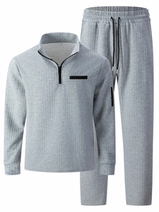 Detail of grey waffle knit tracksuit showing the quarter-zip collar and size M label