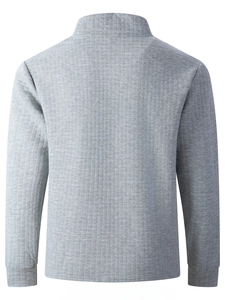 Close-up of men's gray sweatshirt featuring textured grid fabric and ribbed cuffs