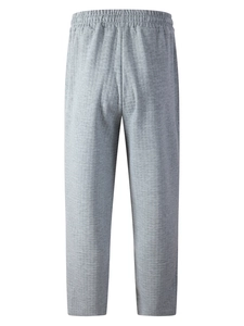 Detail of grey knitted pants featuring vertical stripe texture and elastic drawstring waist