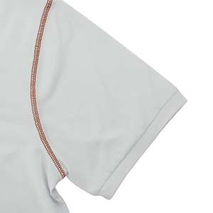 Détail de la manche d'un polo blanc avec coutures plates contrastées rouge-brun