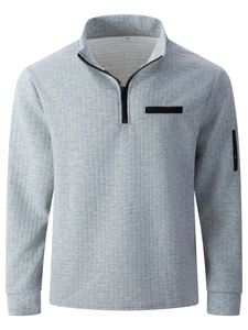 Detail of grey polo sweatshirt featuring waffle texture and arm zipper pocket
