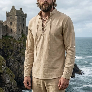 Close-up of beige linen Henley shirt with lace-up collar detail against seaside cliff