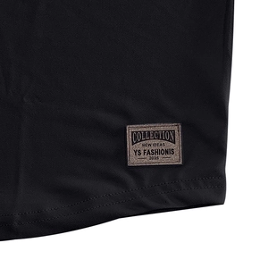 Close-up of black cotton shirt hem featuring a vintage YS FASHIONIS woven decorative label